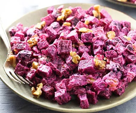 Russian Beet Salad with Prunes and Walnuts in a bowl with a fork/ | www.CuriousCuisiniere.com