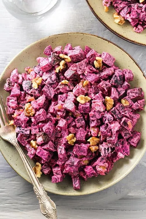 Overhead image of Russian Beet Salad with Prunes and Walnuts in a bowl with a fork/ | www.CuriousCuisiniere.com