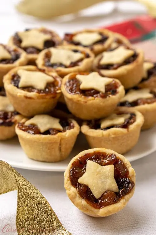 Mince Pies are a British Christmas staple. These sweet and boozy mini fruit pies are the perfect recipe to add to your Holiday cookie platter! | www.CuriousCuisiniere.com