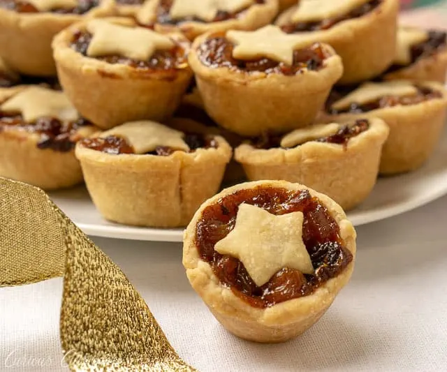 Mince Pies are a British Christmas staple. These sweet and boozy mini fruit pies are the perfect recipe to add to your Holiday cookie platter! | www.CuriousCuisiniere.com