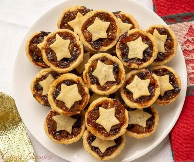Mince Pies are a British Christmas staple. These sweet and boozy mini fruit pies are the perfect recipe to add to your Holiday cookie platter! | www.CuriousCuisiniere.com