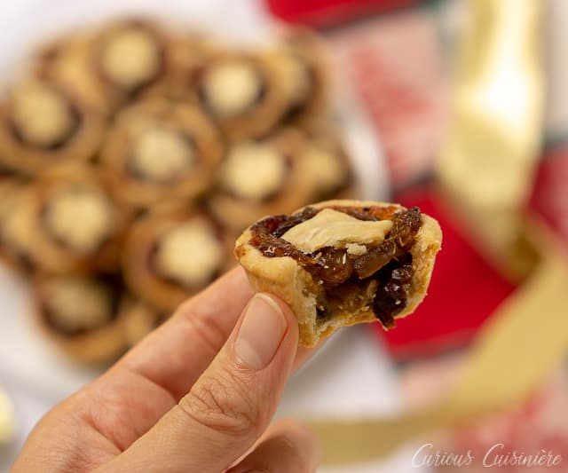 Taking a bite of mini mince pies, the perfect treat for your Christmas cookie platter! | www.CuriousCuisiniere.com