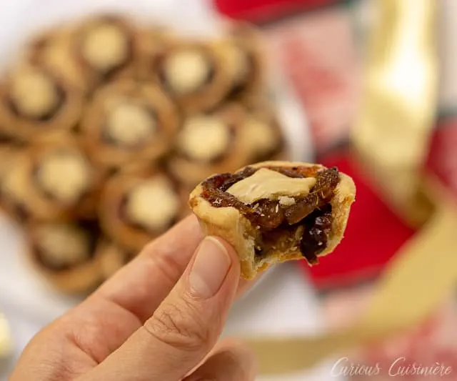 Taking a bite of mini mince pies, the perfect treat for your Christmas cookie platter! | www.CuriousCuisiniere.com