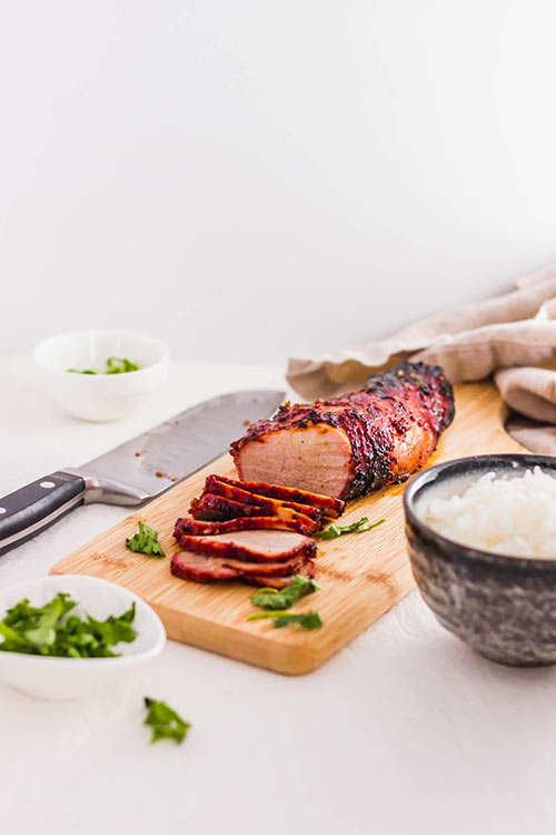 Homemade Chinese BBQ Pork Tenderloin with a side of rice and a knife for slicing. | www.CuriousCuisiniere.com