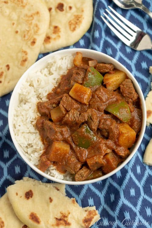 This Madras Curry is a warming dish that is perfect for a cool evening. This slow cooker beef curry brings deep, comforting flavors and tender meat with little effort. | www.CuriousCuisiniere.com