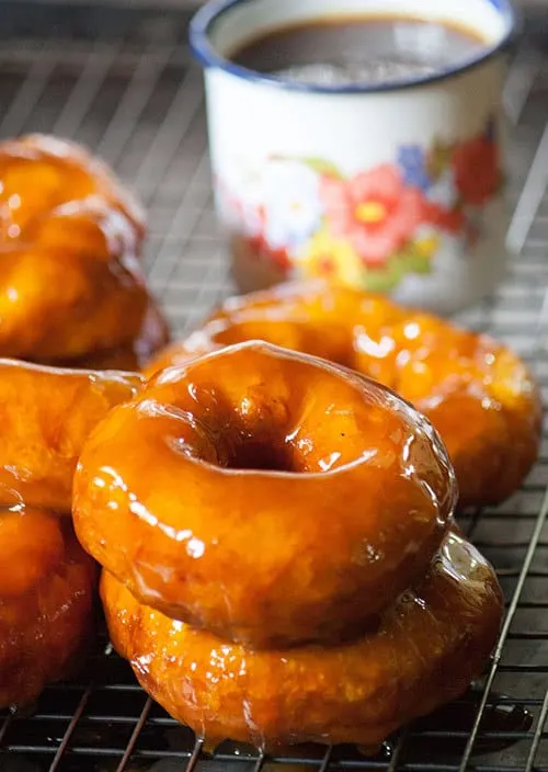 Picarones are Chilean style donuts. These soft, squash or pumpkin donuts are soaked in an orange infused syrup made with panela. | www.CuriousCuisiniere.com