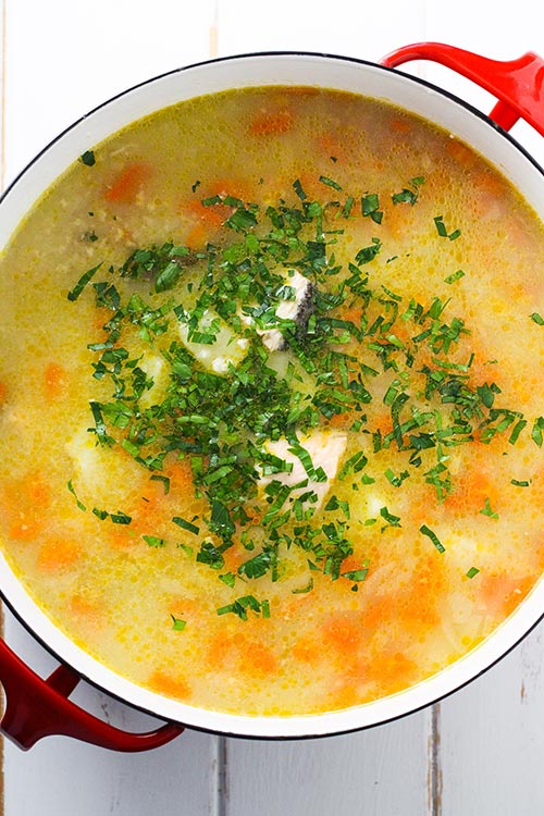  Vista aérea de una olla de Ukha, sopa de pescado rusa. El pescado se cocina suavemente con papas y zanahorias en un caldo rico sazonado con bahía y pimienta negra. | www.CuriousCuisiniere.com
