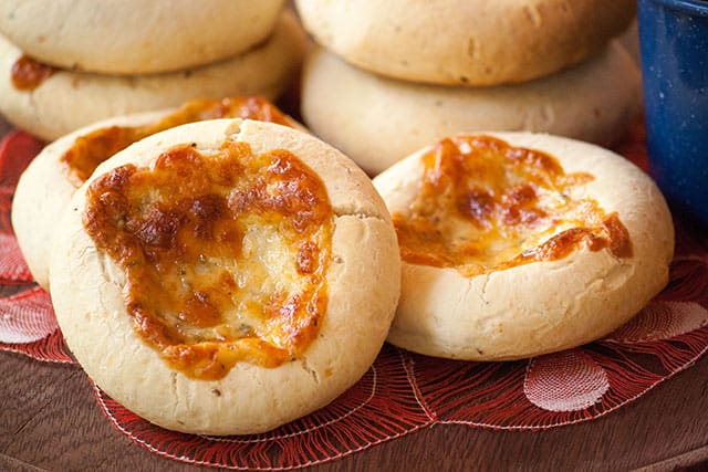 Chipa 4 quesos, cassava and cheese bread from Paraguay stacked together on a red napkin. 