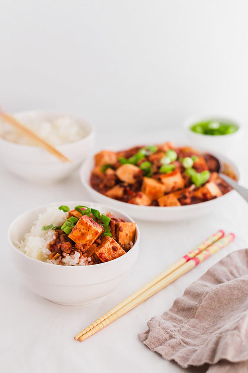Often found in Chinese restaurants, Mapo Tofu is a quick Chinese Sichuan dinner recipe to make at home. This is an easy and flavorful way to prepare tofu, with minced meat and an aromatic red sauce. | www.CuriousCuisiniere.com