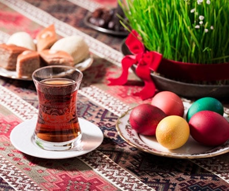Tea, eggs, and treats for celebrating Nowruz along with a pot of sprouts.