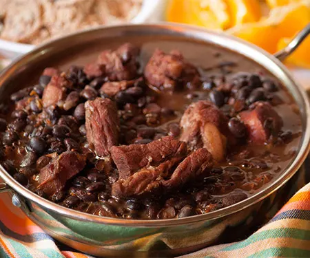 Feijoada, Brazilian black bean stew served with farofa and orange slices