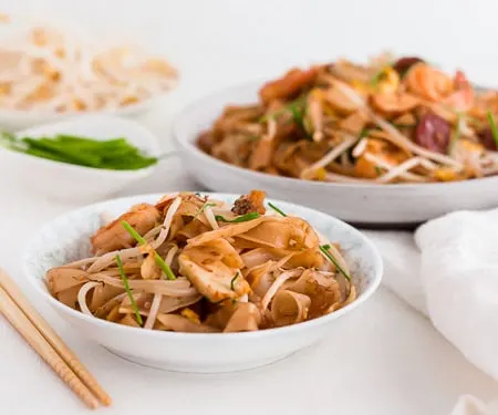 Malaysian Stir Fried Rice Noodles - Char Kway Teow - in a small bowl for serving with bean sprouts and chives