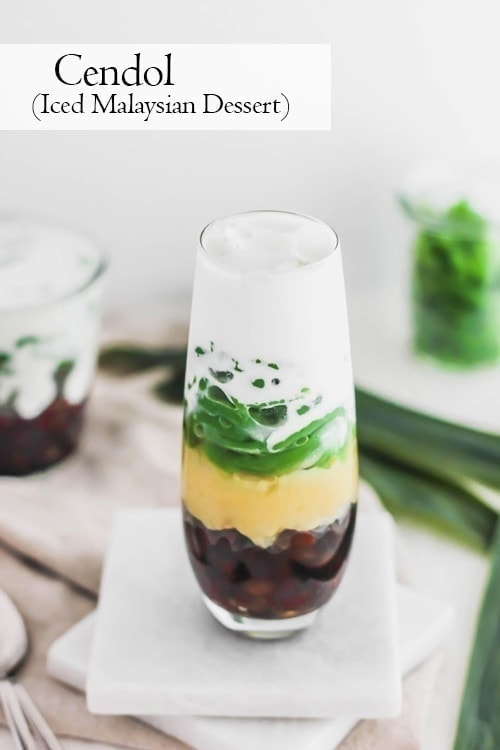 Top view of cendol, Malaysian pandan jellies, layered with red azuki beans, yellow mung beans, and coconut milk in a glass. 