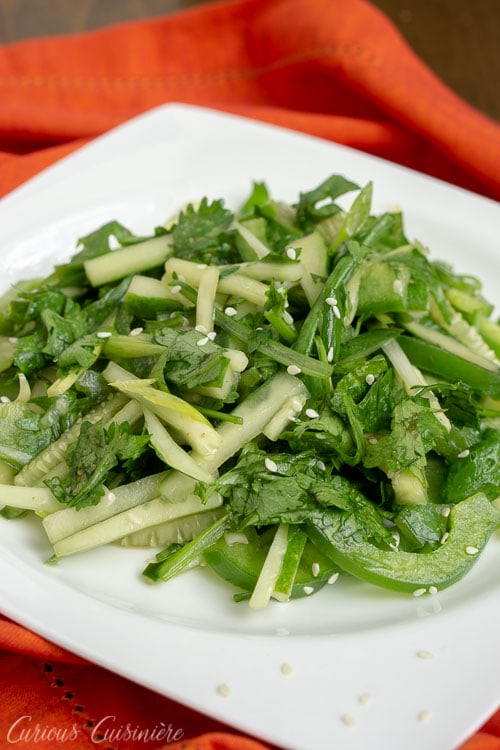 Chinese Tiger Salad - Lao Hu Cai - with cucumbers, cilantro, green peppers in a sesame oil dressing. on a white plate. 