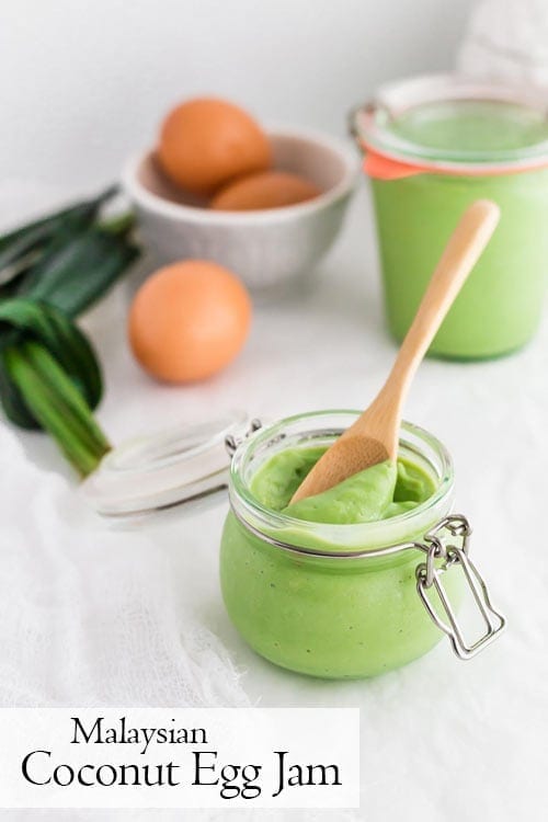Pandan Coconut Jam in a swing top canning jar with a wooden spoon, eggs and pandan leaves