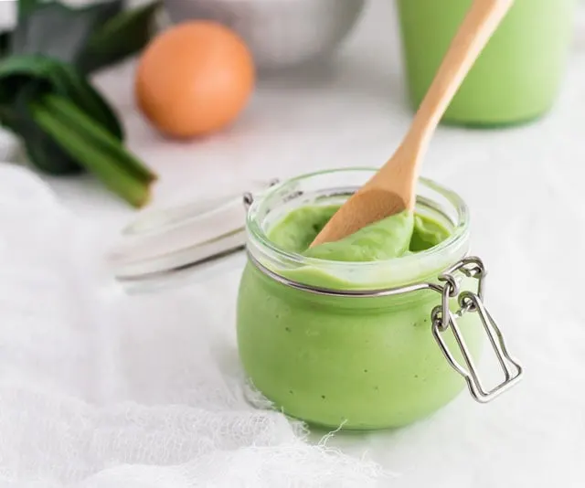 Pandan Coconut Jam in a swing top canning jar with a wooden spoon