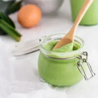 Pandan Coconut Jam in a swing top canning jar with a wooden spoon