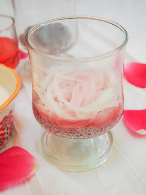 Rose syrup and basil seeds in a glass with noodles for falooda