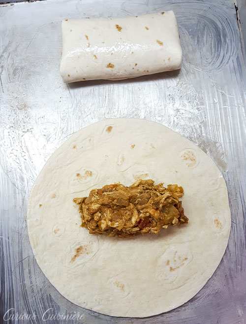 Filing tortillas with chicken filling for chimichangas