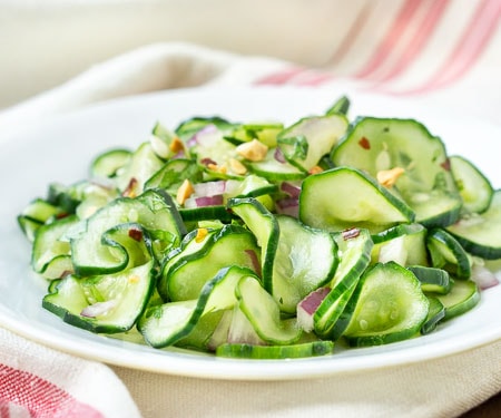 Thinly sliced cucumber with red onion sand peanuts - horizontal image.