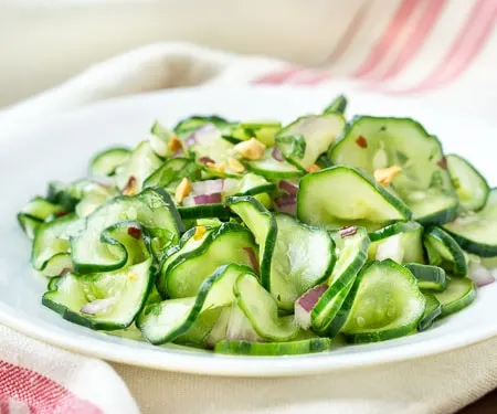Thinly sliced cucumber with red onion sand peanuts - horizontal image.