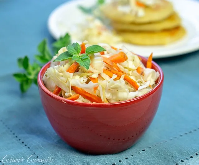 El Salvadoran Curdito pickled cabbage and carrot slaw in a red bowl