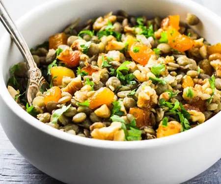 Mshosh Armenian lentil salad with apricots, and walnuts with a fork.