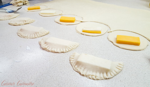 Filling and sealing Brazilian Pastel de Queijo, cheese pastries