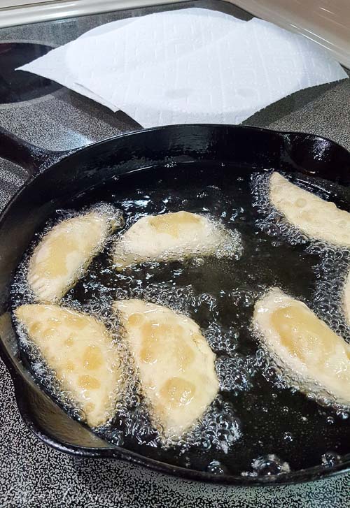 Frying Brazilian Pastel de Queijo, cheese pastries