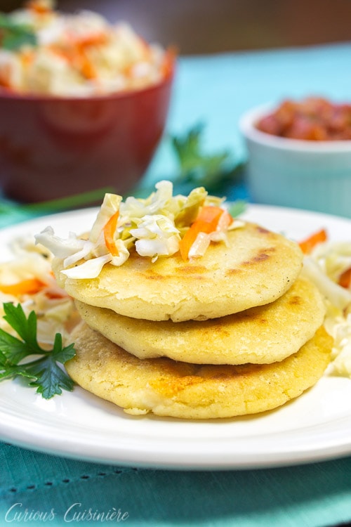 El Salvadoran pupusas, cheese stuffed tortillas, stacked with cabbage slaw on top