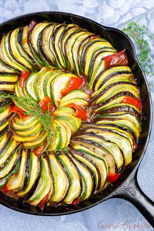 Overhead image of layered ratatouille in a cast iron skillet