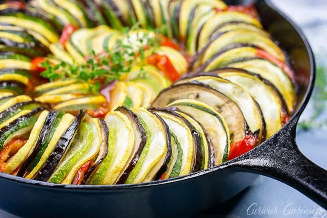 Up close pan shot of layered ratatouille in a cast iron skillet
