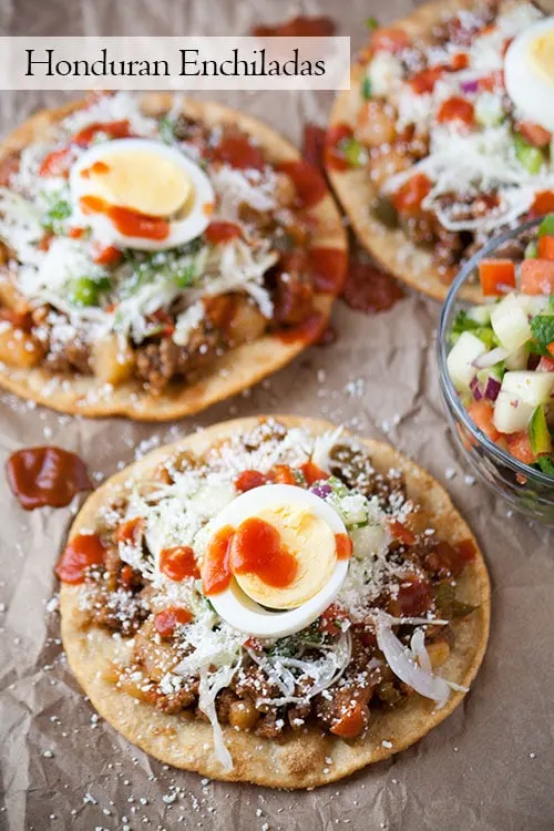Not like the enchiladas you may first think of, Honduran enchiladas are made in the style of a tostada. Crispy corn tortillas, piled with meat, veggies, cheese, and eggs create this delicious street food.