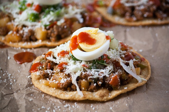 Honduran enchiladas with beef, hard boiled egg, and tomato sauce up close