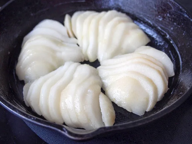 Pears sliced in cast iron skillet.