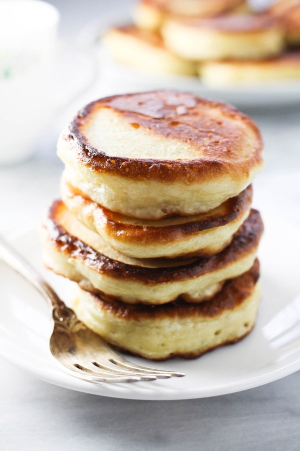 Oladi (Russian Yeast Pancakes) stacked on a plate
