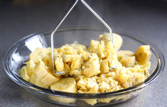 Mashing green plantains for fritters