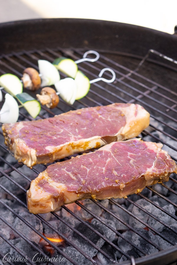 Hibachi steak on a charcoal grill with veggie skewers