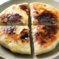 Imeruli Khachapuri - Georgian cheese filled bread cut into quarters feature image