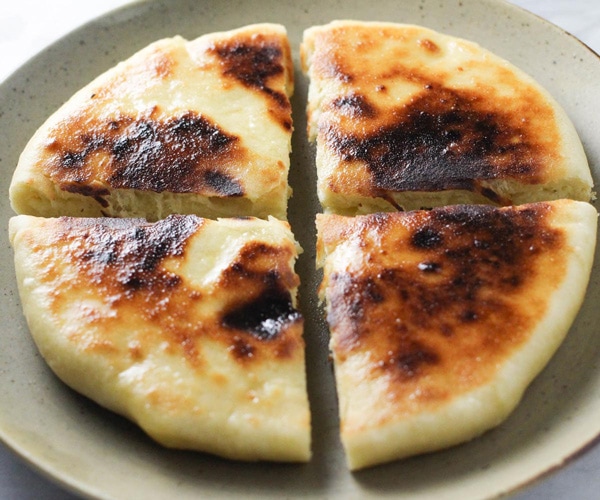 Imeruli Khachapuri - Georgian cheese filled bread cut into quarters feature image