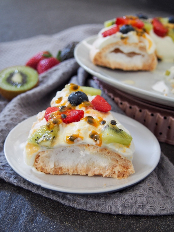 Slice of Christmas Pavlova wreath topped with fruit