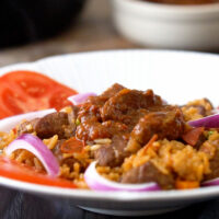Jollof rice with beef topped with beef stew