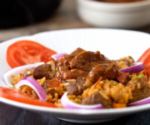 Jollof rice with beef topped with beef stew