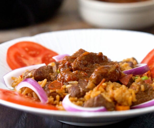 Jollof rice with beef topped with beef stew