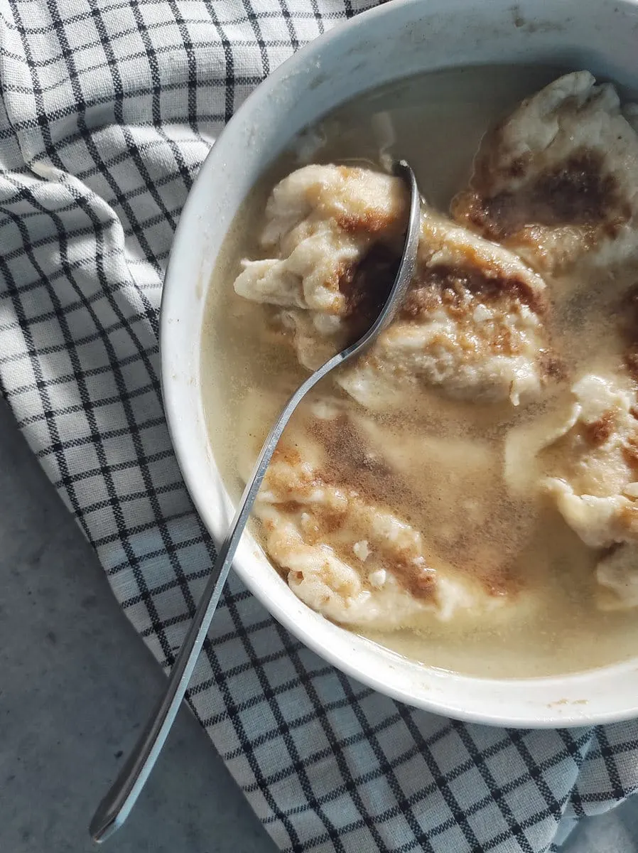 Cutting Zagorski Štrukli Served in Soup (Croatian Cheese Dumpling Soup)