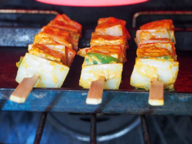 Cooking Paneer Tikka under a broiler