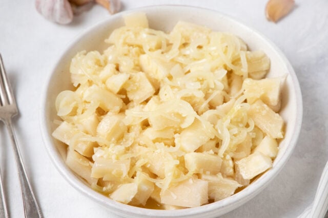 Cuban Yuca con Mojo - Cassava with garlic sauce in a serving bowl close up