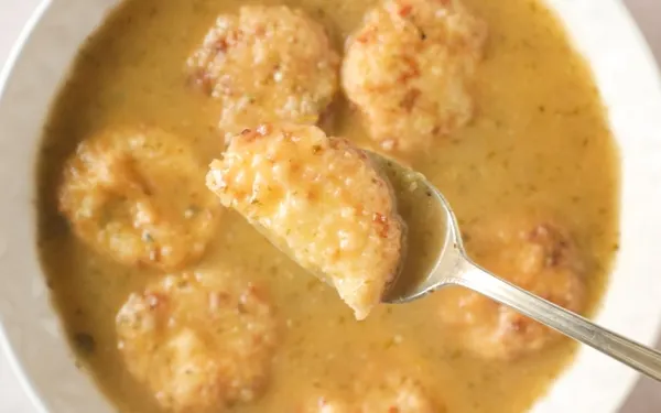 Sopa de Capirotadas (Honduran Dumpling Soup) with cut cheese dumpling in spoon