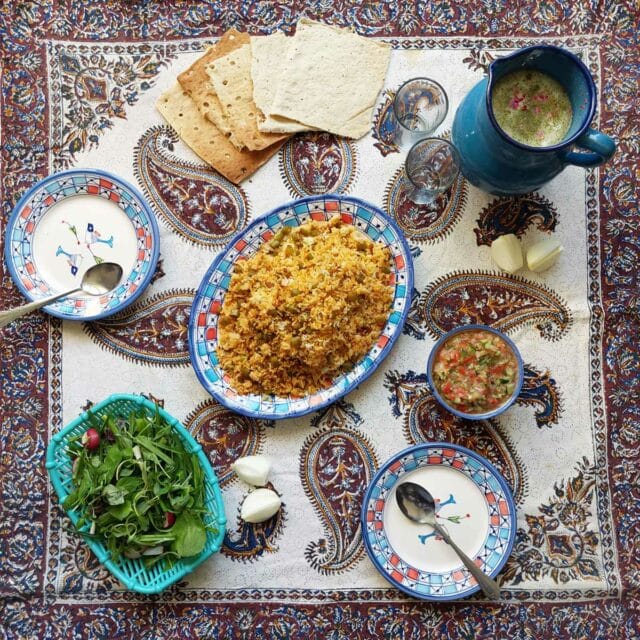 Estanboli Iranian tomato rice served for a meal with herb salad, lavash, doogh
