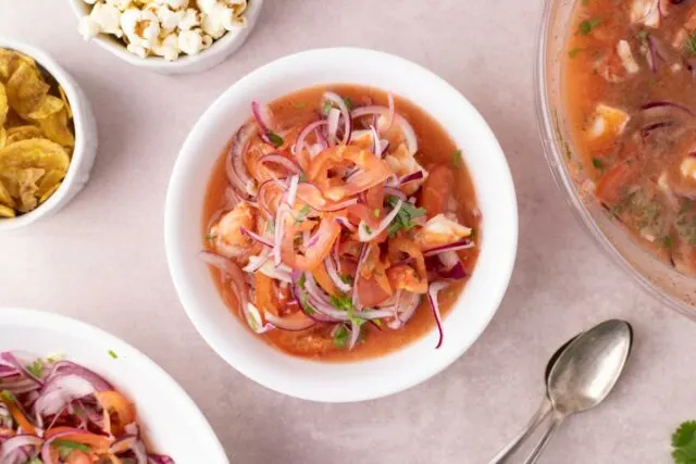 Ecuadorian cooked shrimp ceviche - shrimp soup with tomato and lime, served with popcorn